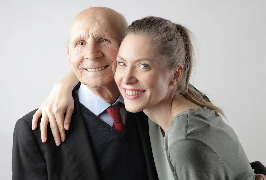 Happy elderly man in a suit hugging a smiling woman, capturing a joyful family moment perfect for inspiring Father’s Day gift ideas.