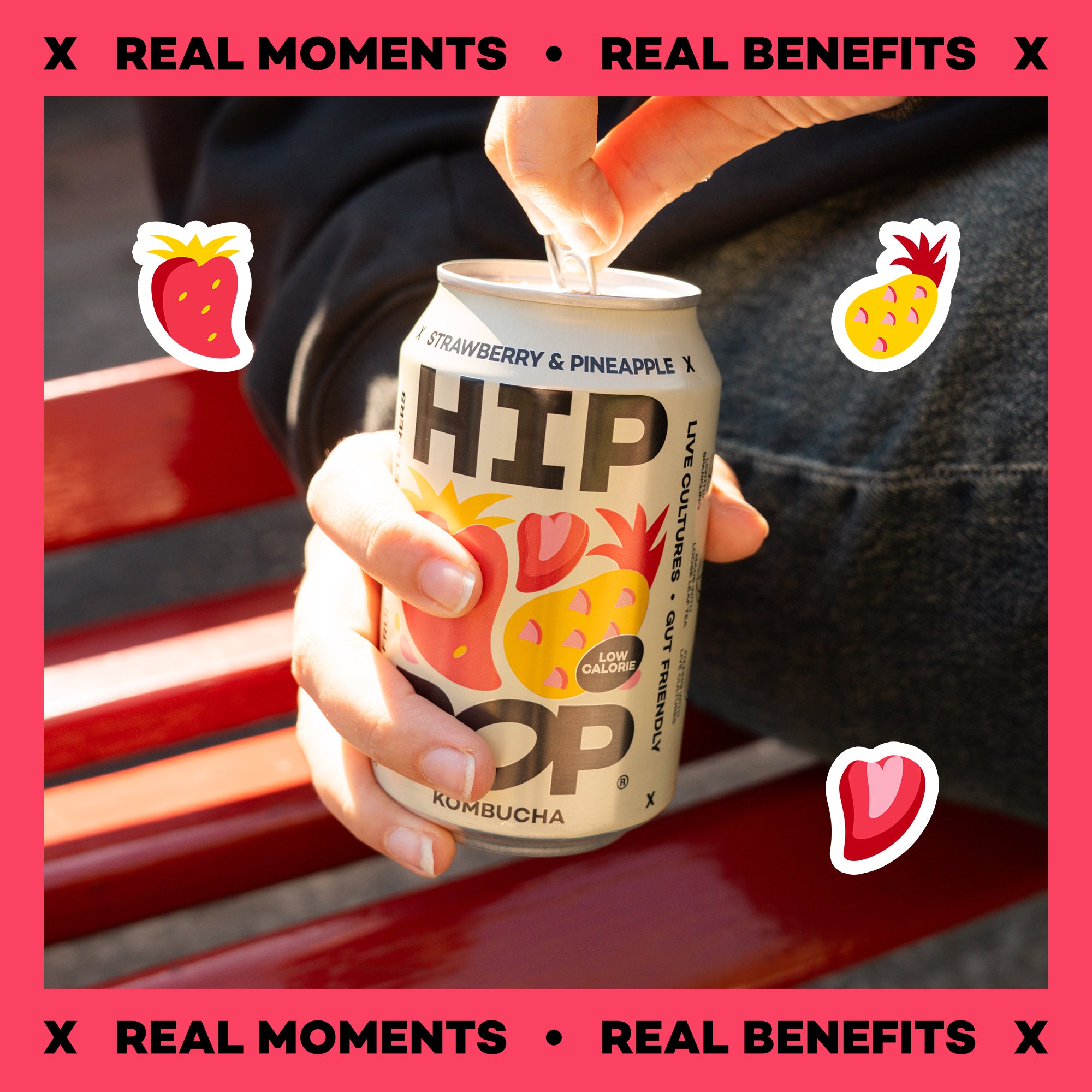 Hand holding a can of HIP Strawberry & Pineapple Kombucha with pink border and graphics with text that say "Real Moments" and "Real Benefits".