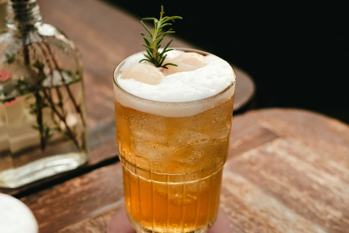 a glass of beer sitting on top of a wooden table