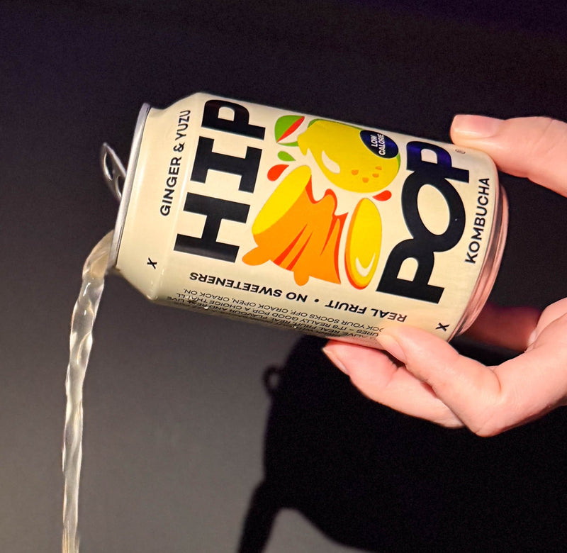 A can of Hip Pop Ginger & Yuzu kombucha being poured out, highlighting its real fruit content and natural ingredients; a refreshing option when considering the best time to drink kombucha.
