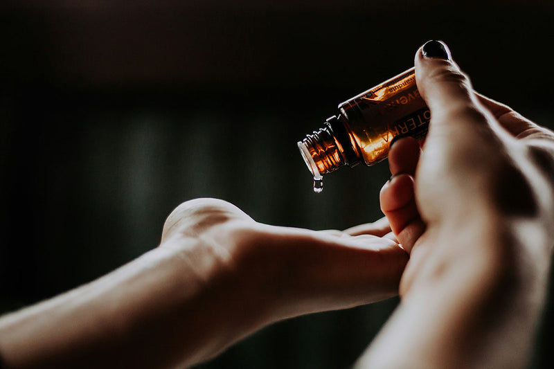 womans hand holding bottle of flavour oil 