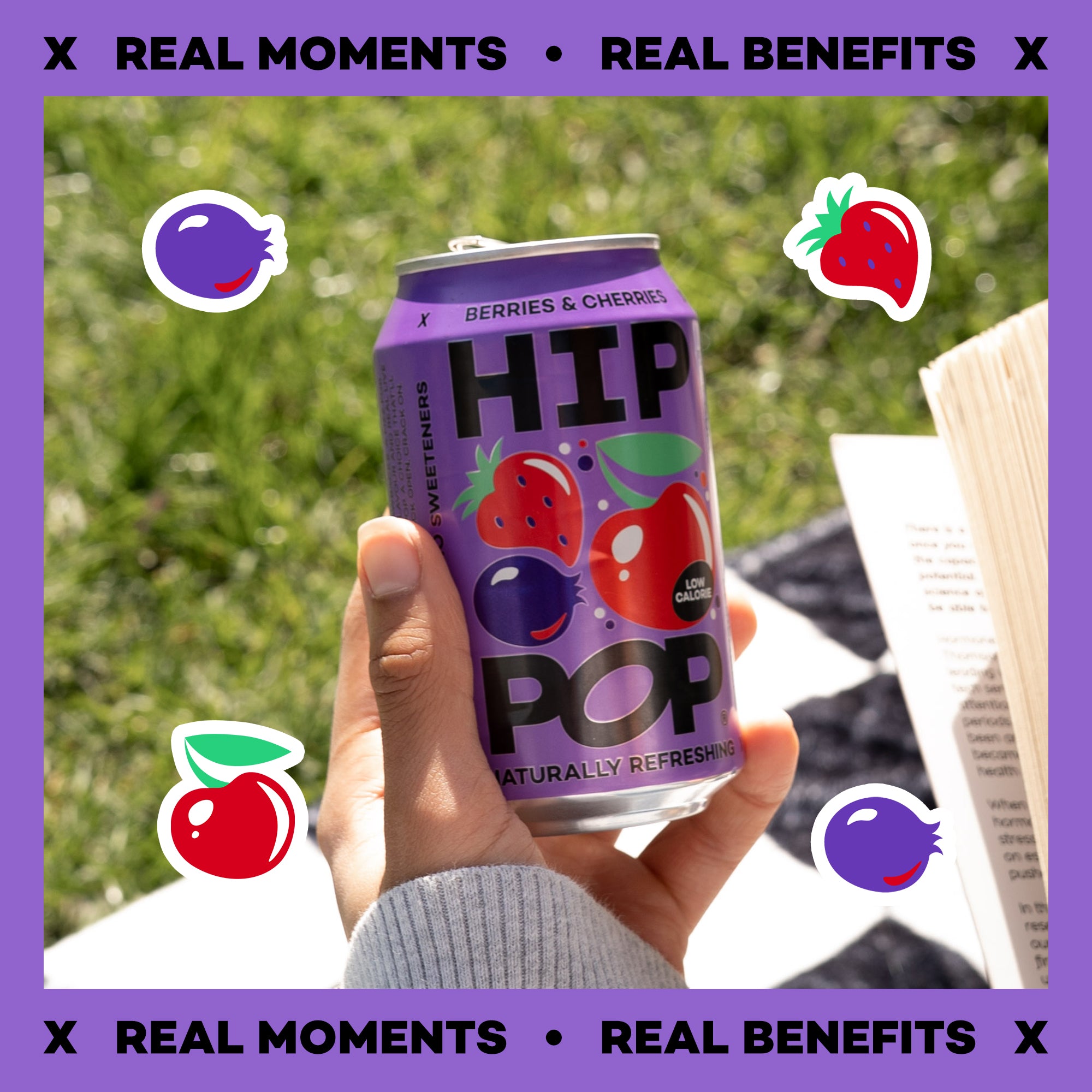 Hand holding a can of HIP Pop sparkling water with berries and cherries flavor against a grassy background.